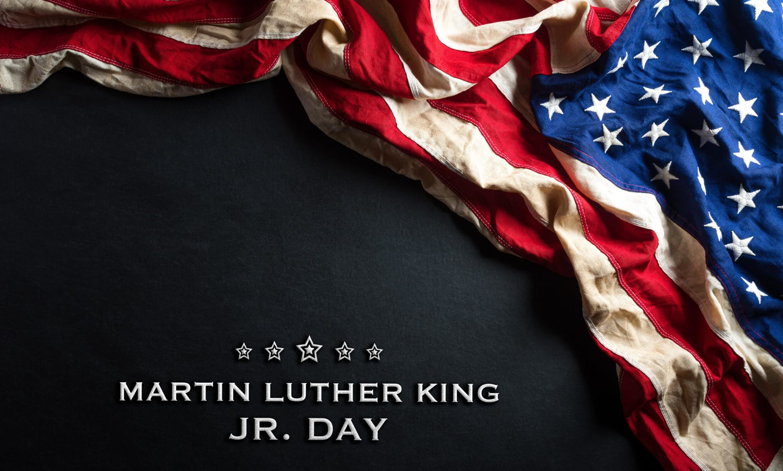 American flag against black background with text reading Martin Luther King Jr. Day.